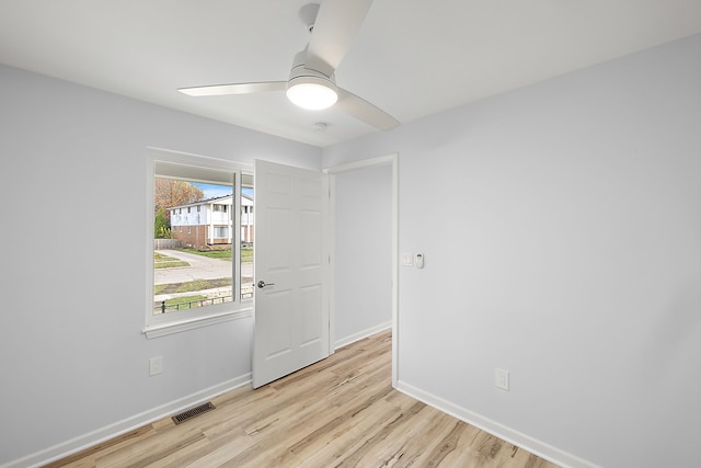 spare room with visible vents, ceiling fan, baseboards, and wood finished floors