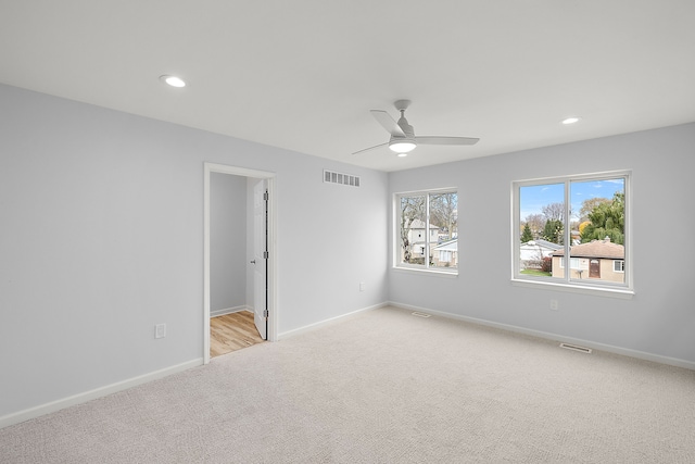 unfurnished room with recessed lighting, baseboards, visible vents, and light colored carpet