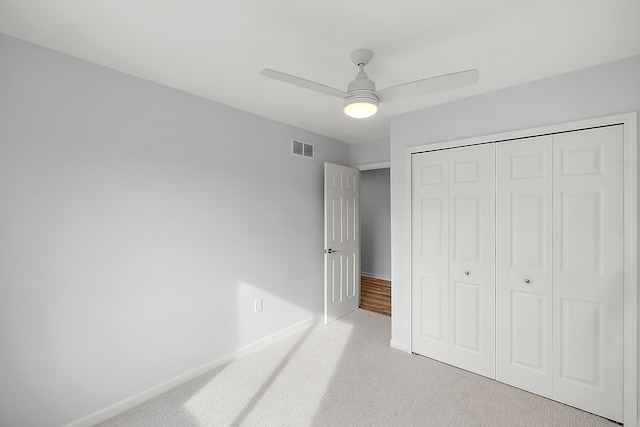 unfurnished bedroom with carpet floors, baseboards, visible vents, and a closet