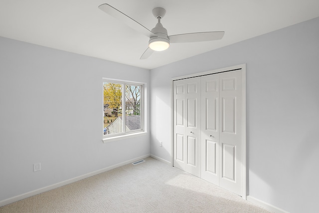 unfurnished bedroom with baseboards, visible vents, a ceiling fan, carpet flooring, and a closet