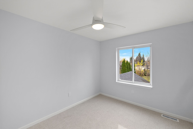 spare room with light carpet, baseboards, visible vents, and ceiling fan