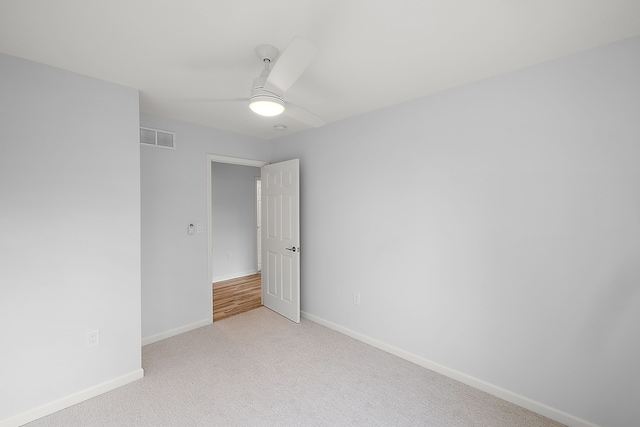 unfurnished room with light carpet, baseboards, visible vents, and ceiling fan