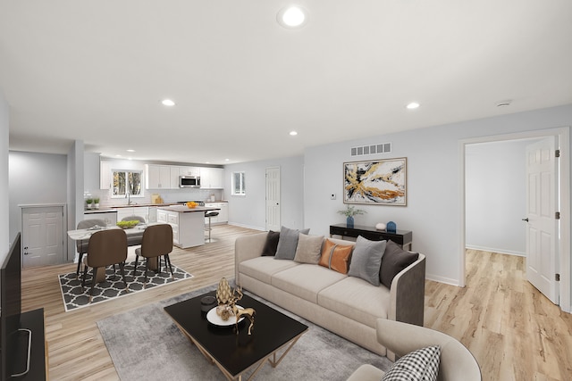 living area featuring light wood-type flooring, recessed lighting, visible vents, and baseboards