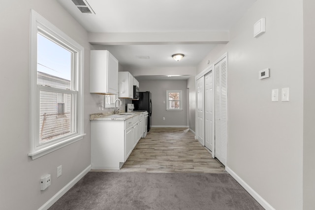 kitchen with sink, white cabinetry, and a wealth of natural light