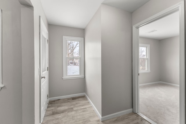 hallway with plenty of natural light and light hardwood / wood-style flooring