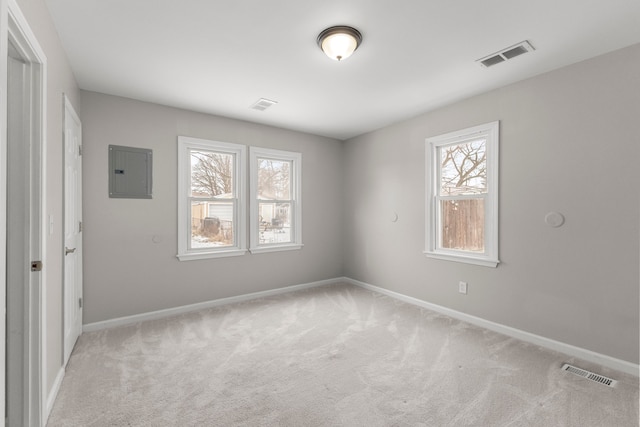 unfurnished room featuring light colored carpet and electric panel