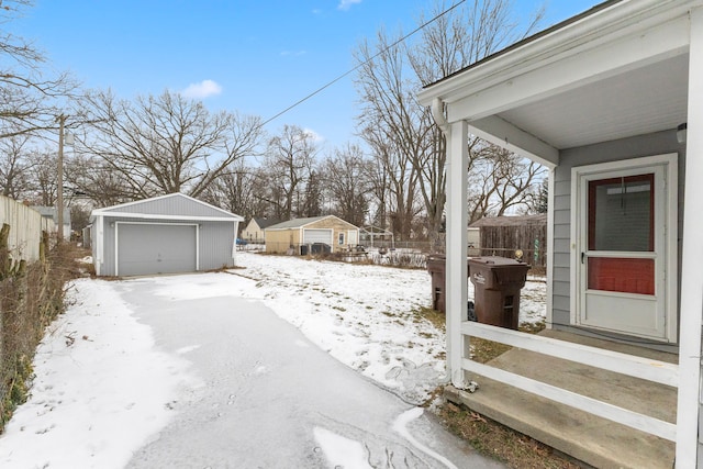 yard covered in snow with a garage and an outdoor structure