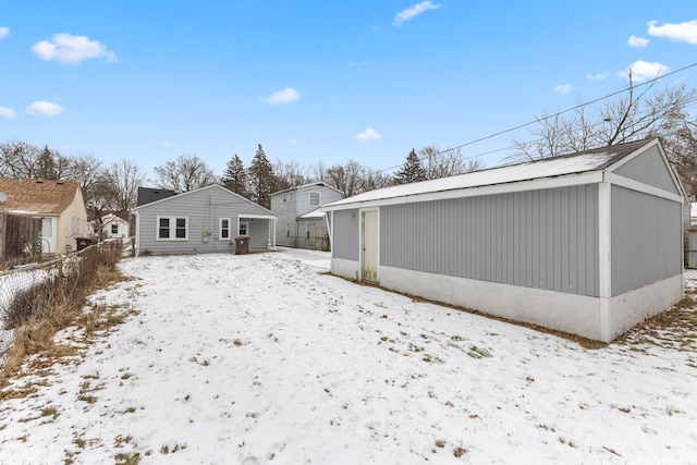 view of snow covered back of property