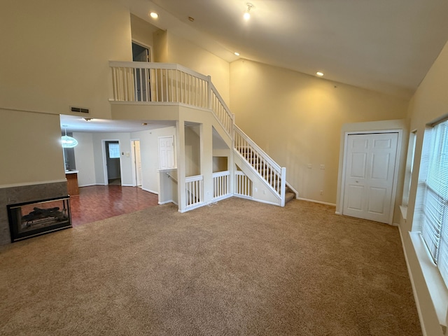 unfurnished living room featuring carpet, recessed lighting, visible vents, stairway, and baseboards