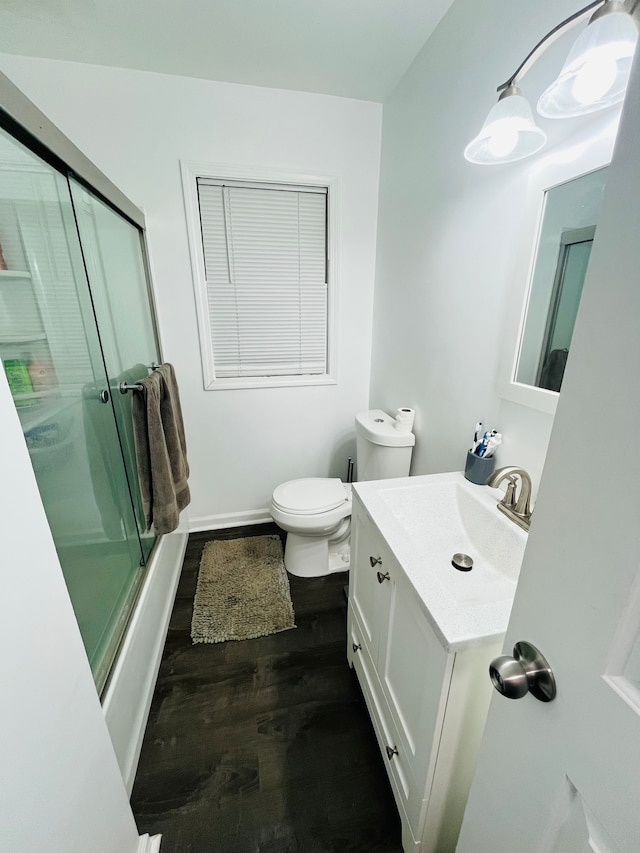 full bathroom with shower / bath combination with glass door, vanity, toilet, and hardwood / wood-style floors