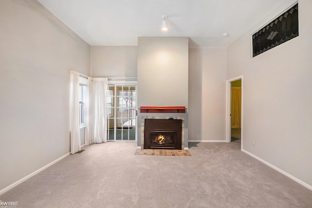 unfurnished living room featuring a high ceiling and light carpet