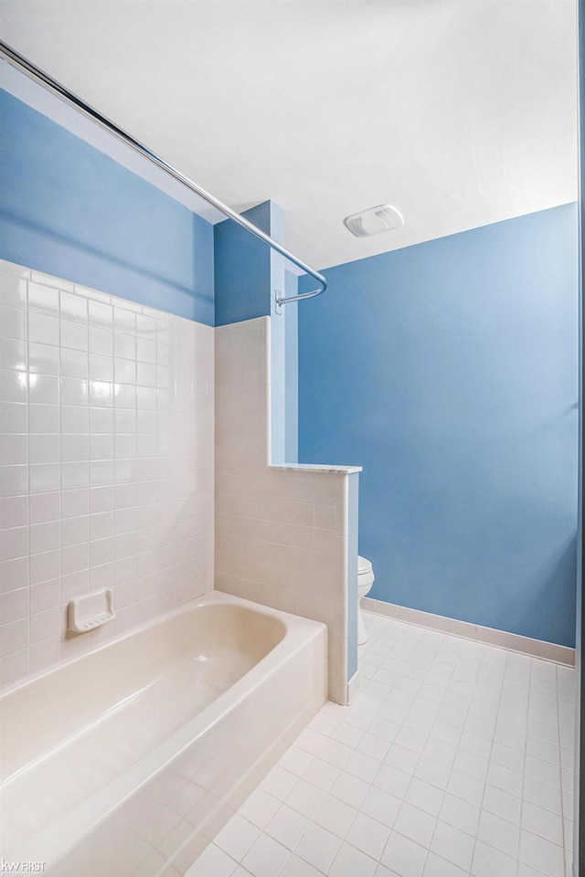 bathroom featuring washtub / shower combination, tile patterned floors, and toilet