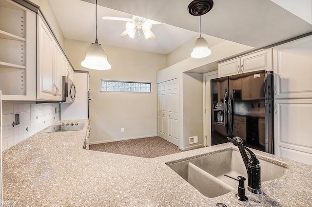 kitchen with sink, backsplash, black appliances, and hanging light fixtures