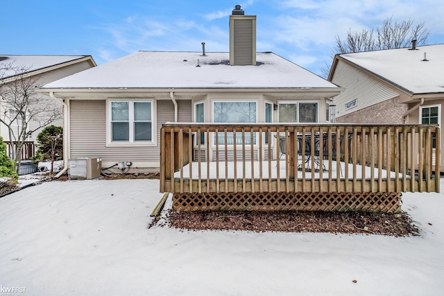 snow covered back of property featuring a deck