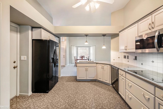 kitchen featuring black appliances, tasteful backsplash, sink, kitchen peninsula, and pendant lighting