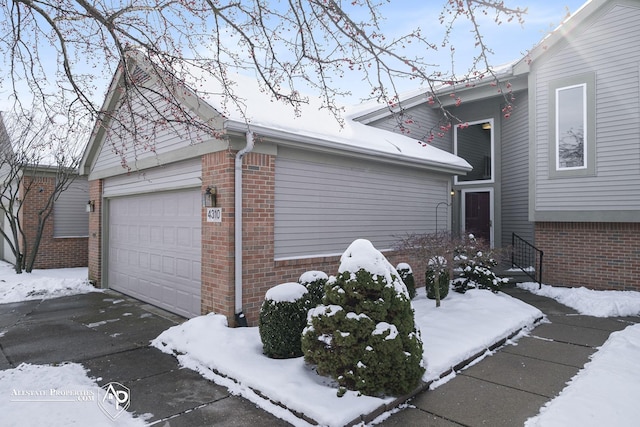 view of snowy exterior with a garage