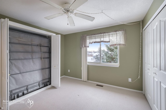 unfurnished bedroom featuring ceiling fan, light colored carpet, and a closet