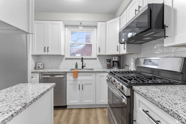 kitchen with sink, light hardwood / wood-style flooring, stainless steel appliances, and white cabinets