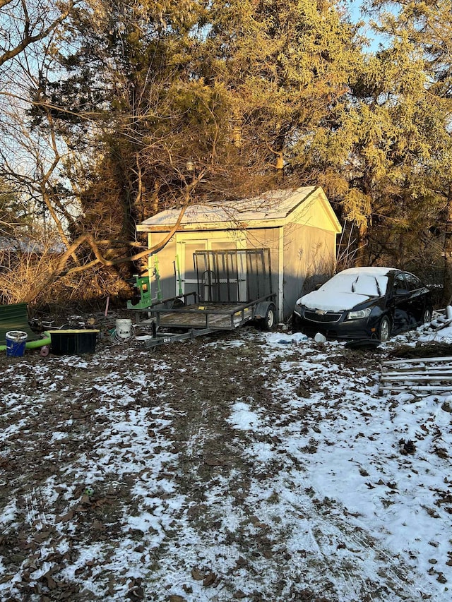 snowy yard featuring an outbuilding