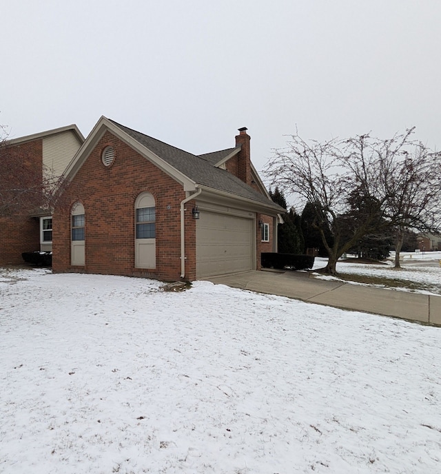 view of snow covered exterior featuring a garage