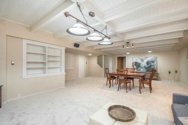 carpeted dining room featuring built in shelves and beamed ceiling