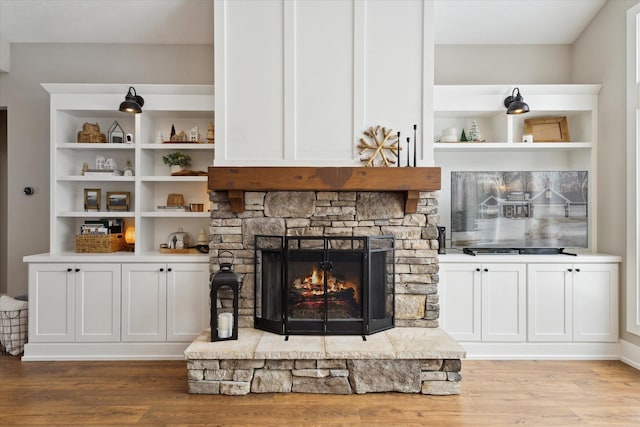 living room with light wood-type flooring and a stone fireplace