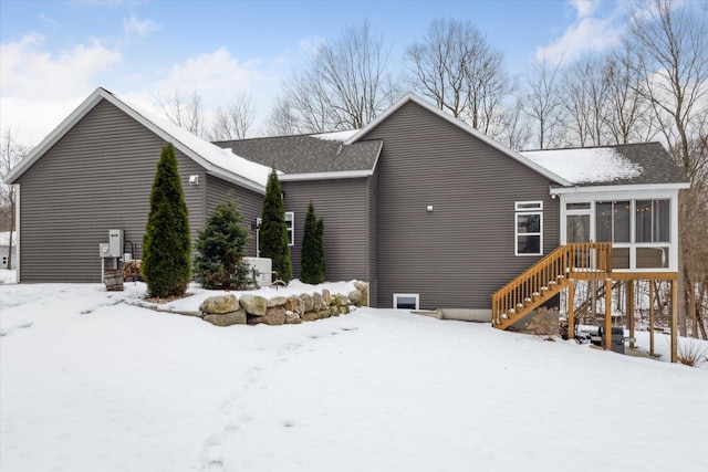 view of snowy exterior featuring a sunroom