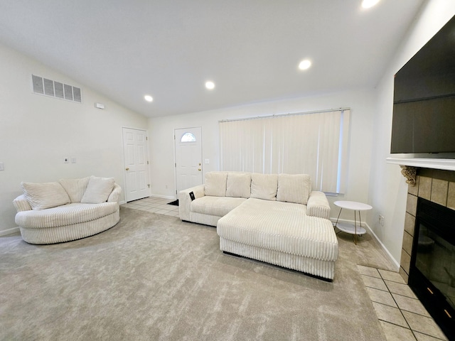 living room with light carpet, vaulted ceiling, and a fireplace