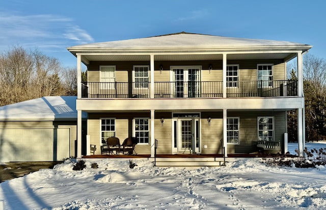 view of front of property with a garage, a balcony, and a porch