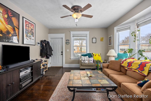 living room featuring a textured ceiling, dark wood-type flooring, and ceiling fan