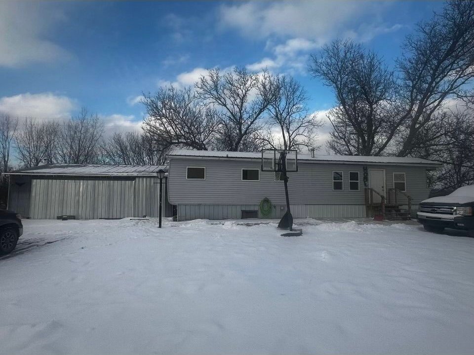 view of snow covered rear of property