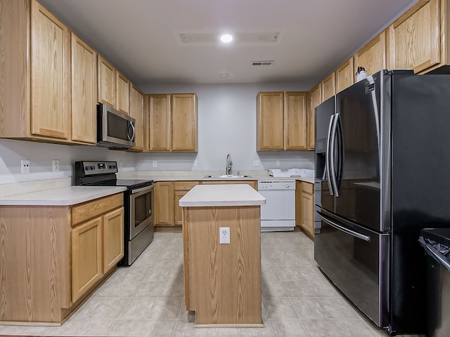 kitchen with sink, stainless steel appliances, a center island, and light brown cabinetry