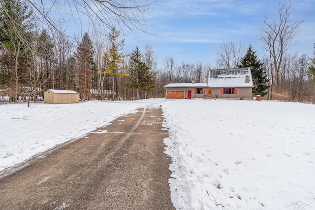 snowy yard featuring a shed