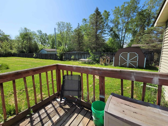 wooden deck featuring a storage shed and a lawn