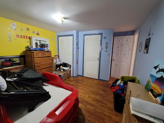 bedroom featuring multiple closets and dark hardwood / wood-style floors