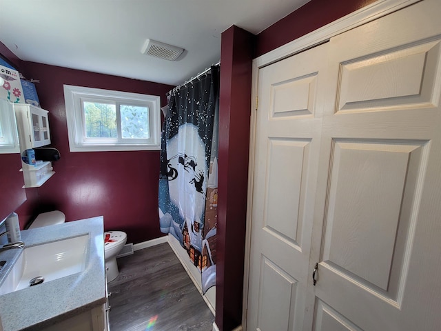 7412 N Webster Rd, Mount Morris, MI 48458 - full bathroom featuring visible vents, baseboards, toilet, wood finished floors, and vanity
