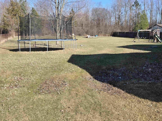 7412 N Webster Rd, Mount Morris, MI 48458 - view of yard featuring a trampoline, playground community, and fence