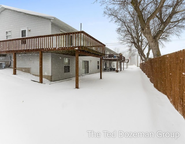 snow covered property featuring a wooden deck