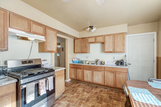 kitchen with stainless steel range with gas cooktop, light brown cabinetry, and sink