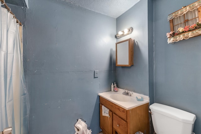 bathroom with vanity, a textured ceiling, and toilet