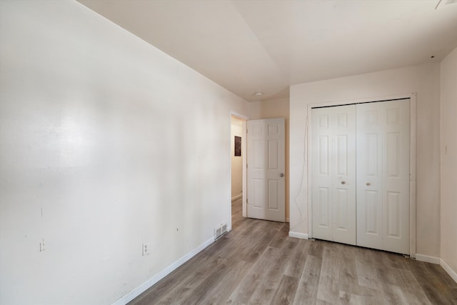 unfurnished bedroom featuring a closet and light wood-type flooring