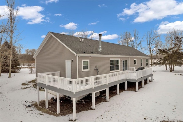 snow covered back of property featuring a wooden deck