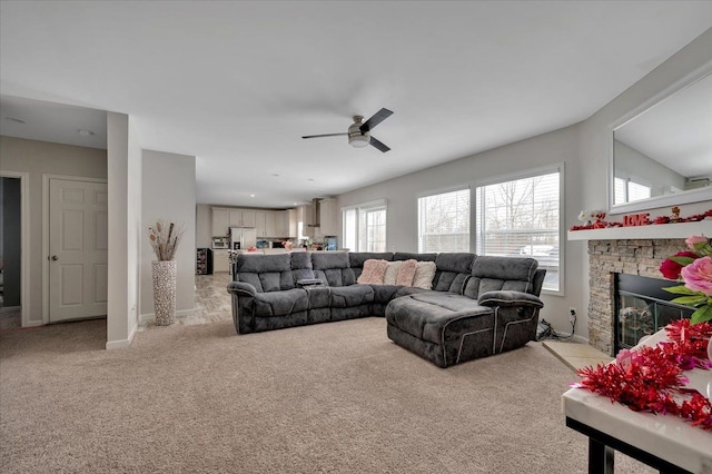 carpeted living room with a fireplace and ceiling fan