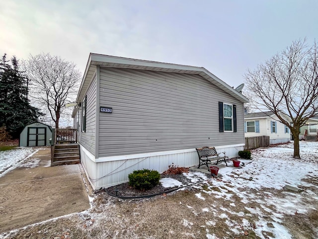 snow covered property with a storage shed