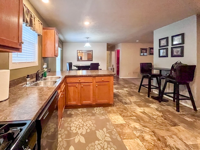 kitchen with pendant lighting, black dishwasher, sink, kitchen peninsula, and stove