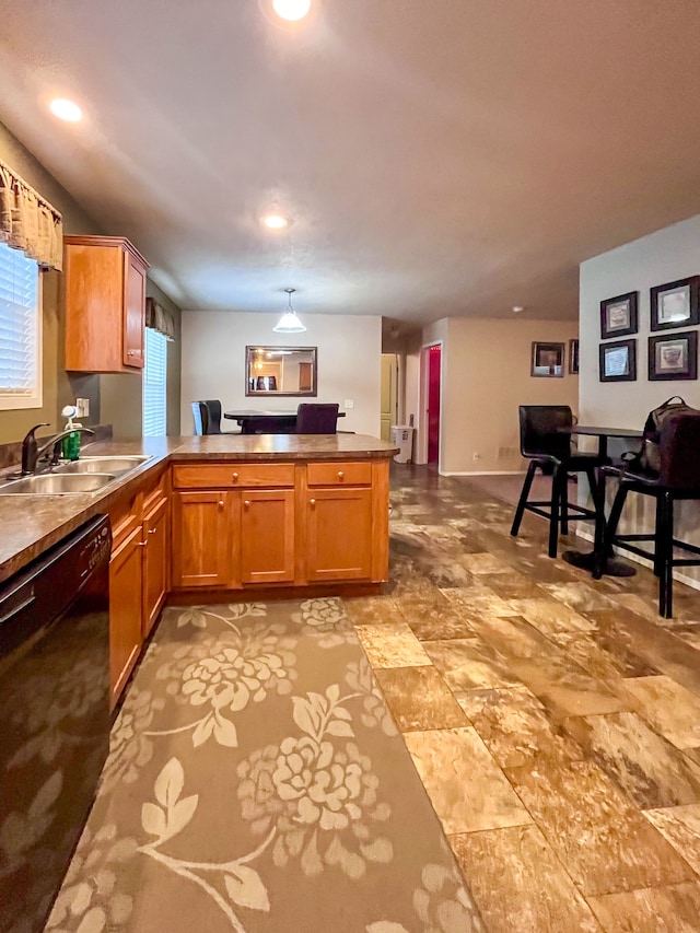 kitchen featuring sink, kitchen peninsula, and black dishwasher