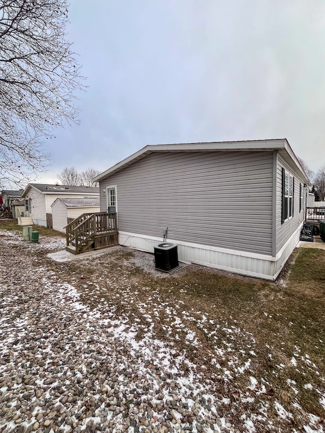 snow covered property featuring central AC