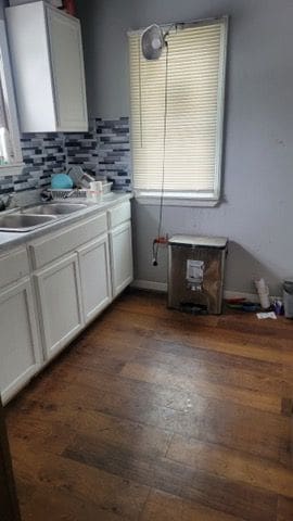 kitchen with sink, white cabinetry, decorative backsplash, and dark hardwood / wood-style floors