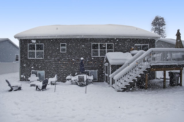 snow covered property with a wooden deck