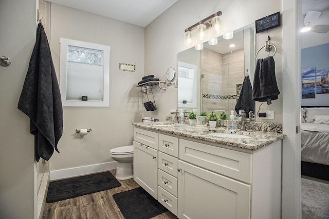 bathroom featuring a shower, hardwood / wood-style floors, toilet, and vanity